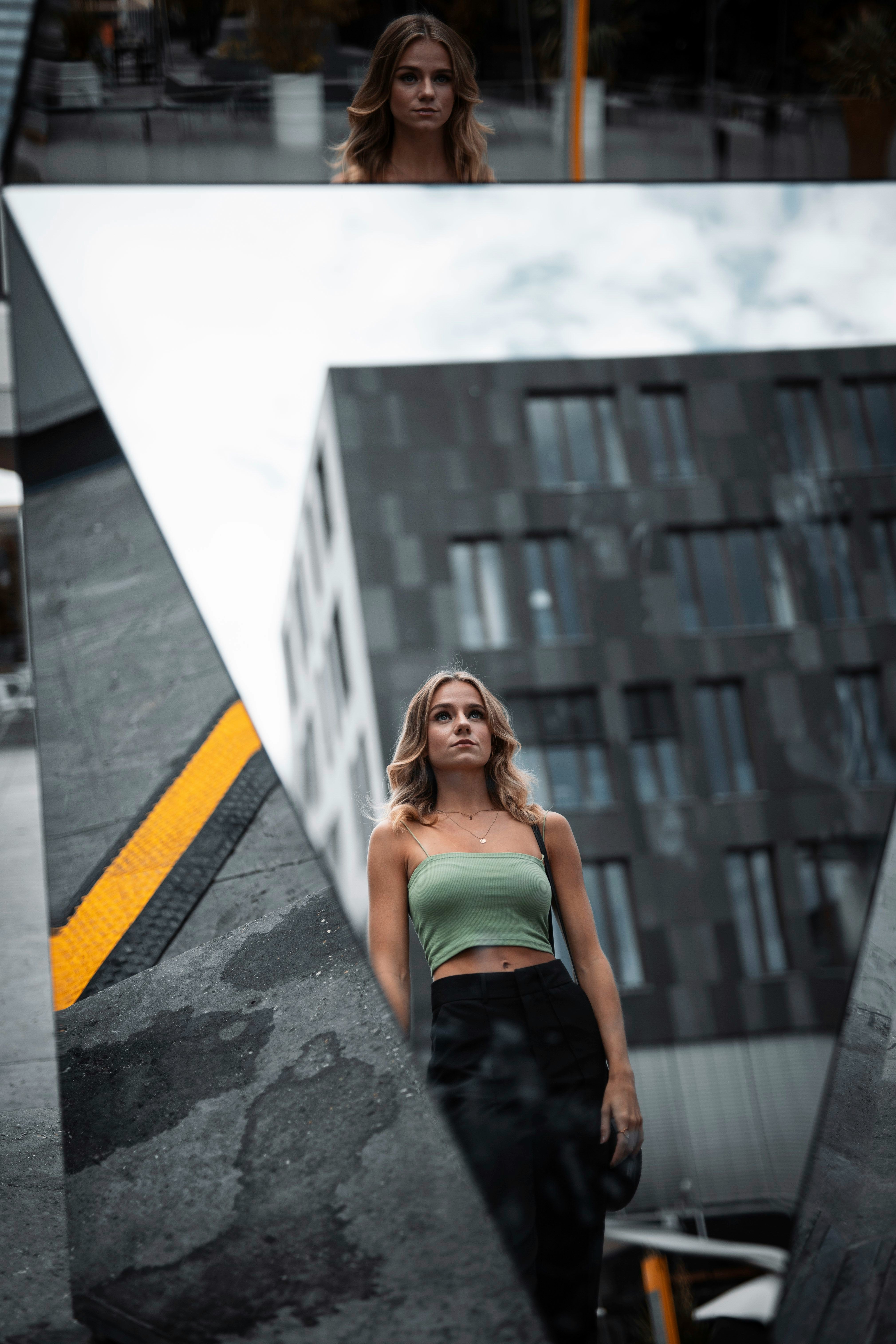 woman in green tube dress standing on gray concrete floor during daytime